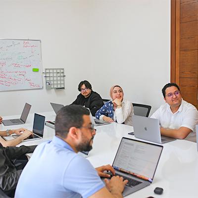 The Chari team collaborating around laptops during a working session at the office